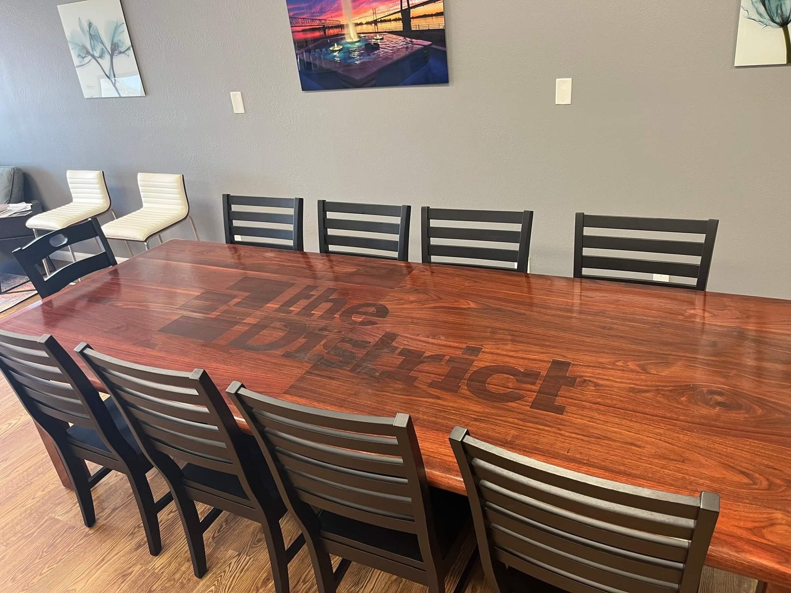 Large custom dining table with an inlaid center design, staged with chairs