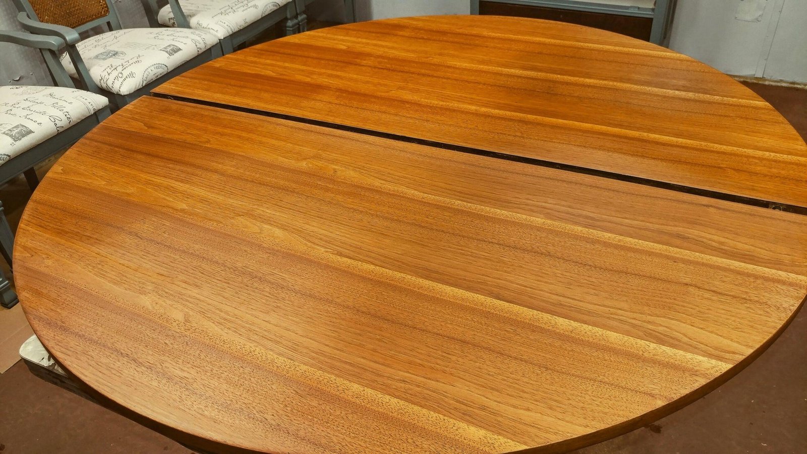 Round plank tabletop after refinishing with a clear warm wood finish