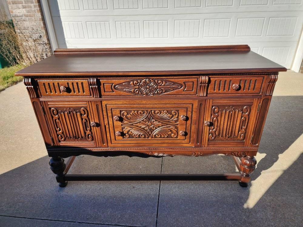 Antique carved wooden sideboard refinished to highlight detailed woodwork.