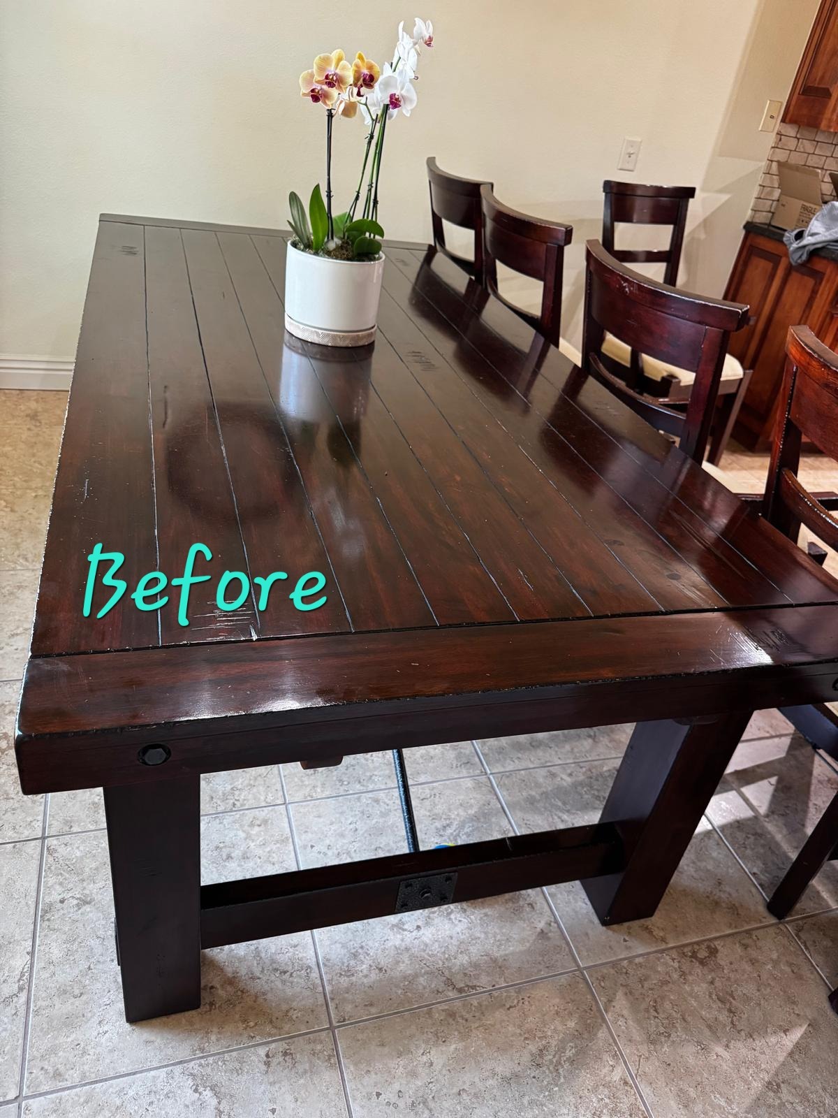 Dark wood farmhouse dining table with scratches before refinishing.