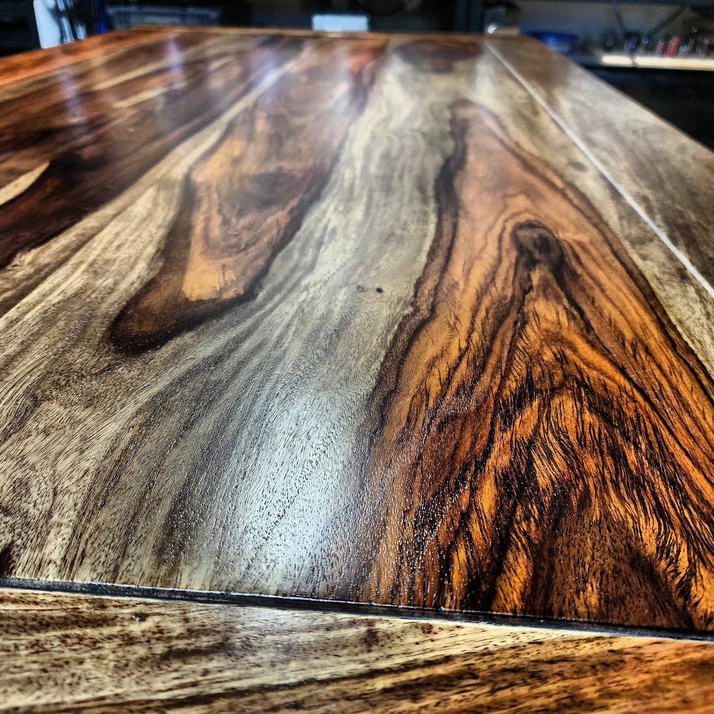 Close-up of a refinished wood tabletop highlighting natural grain patterns.