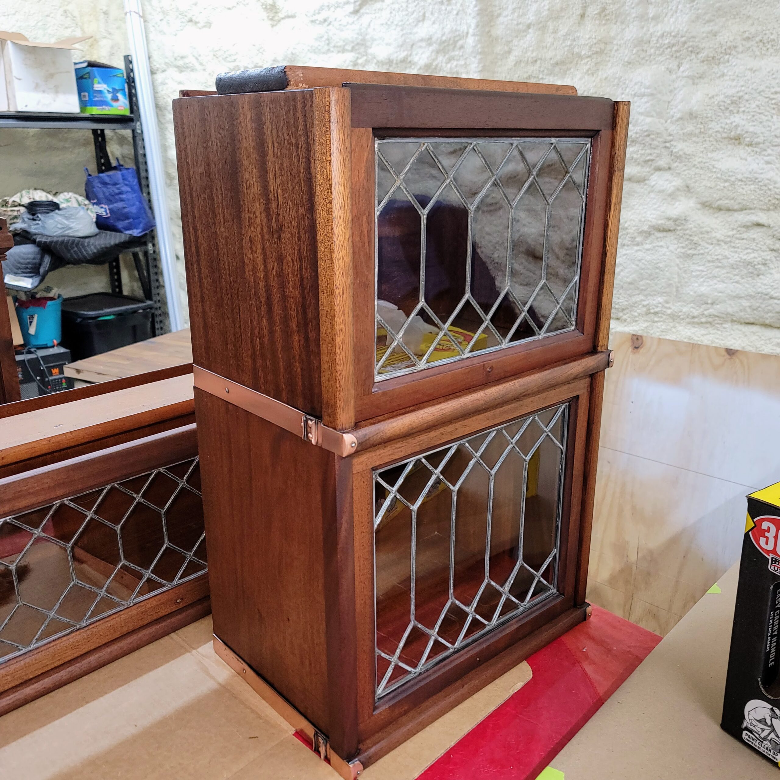 Antique wooden cabinet with leaded glass doors being restored.