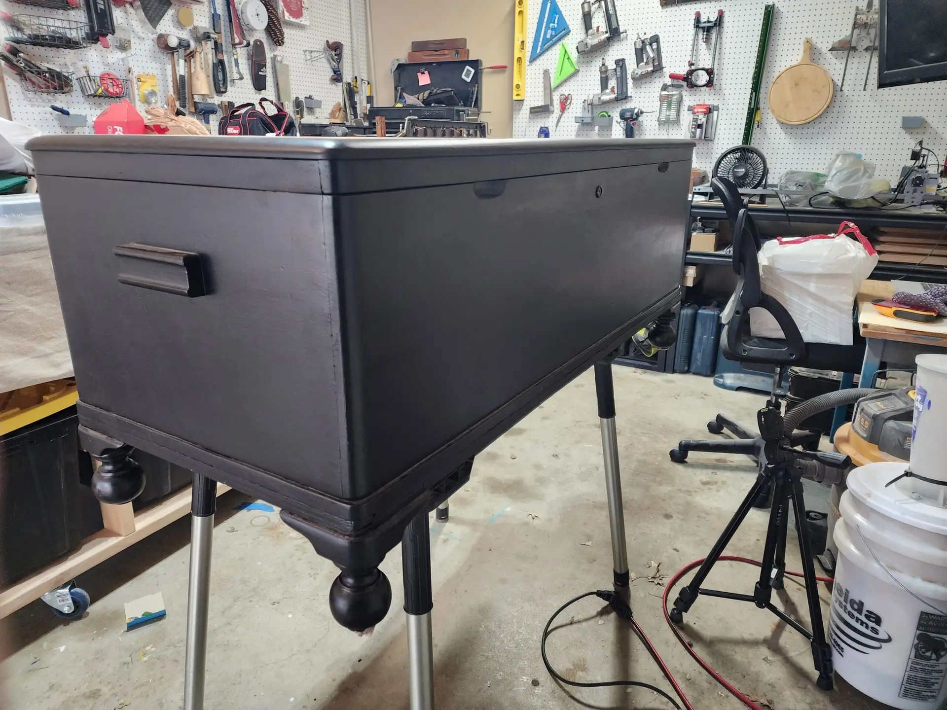 Wood storage box being restored in a furniture refinishing workshop.