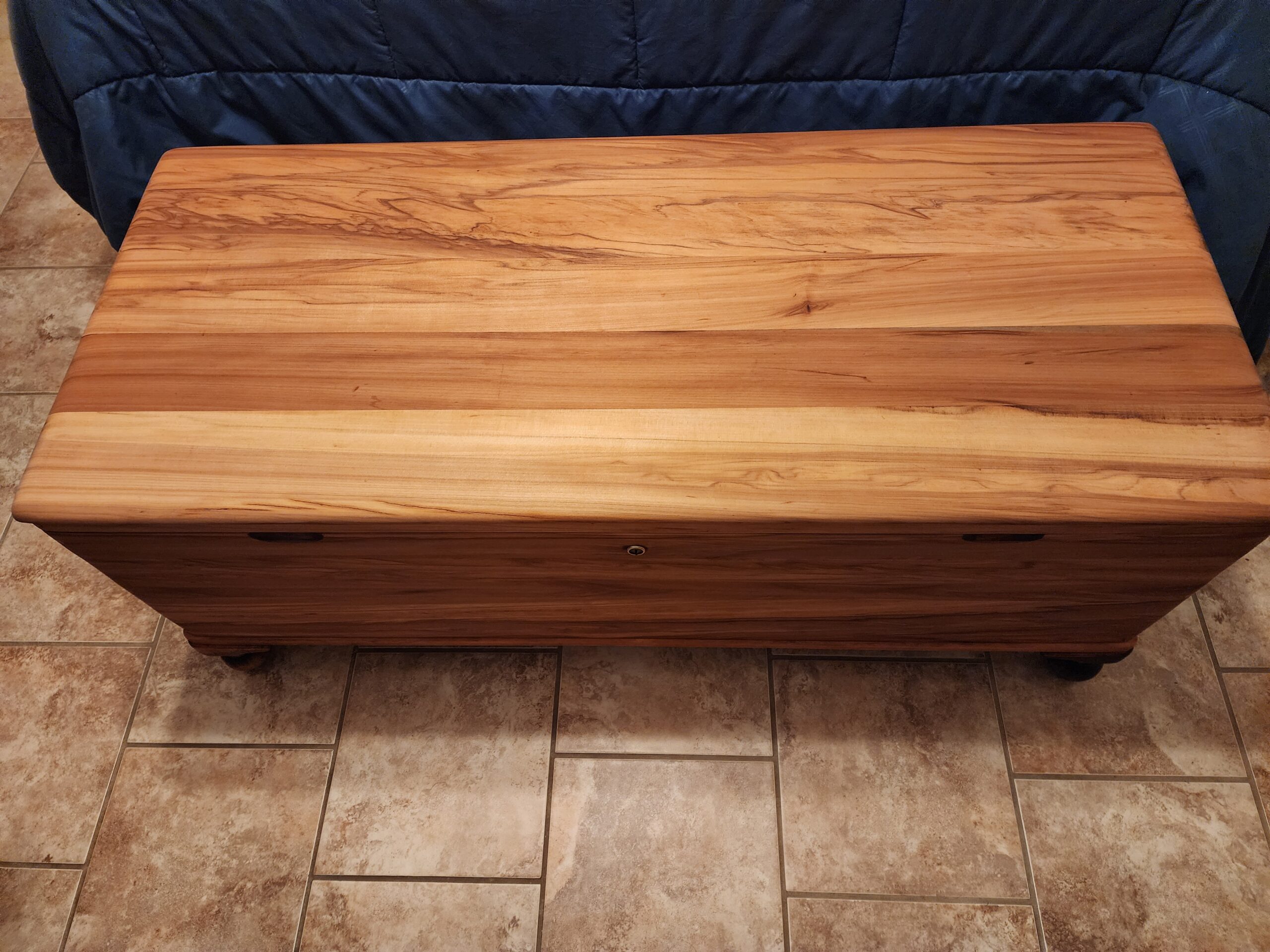 Refinished cedar blanket chest with rich natural wood grain.